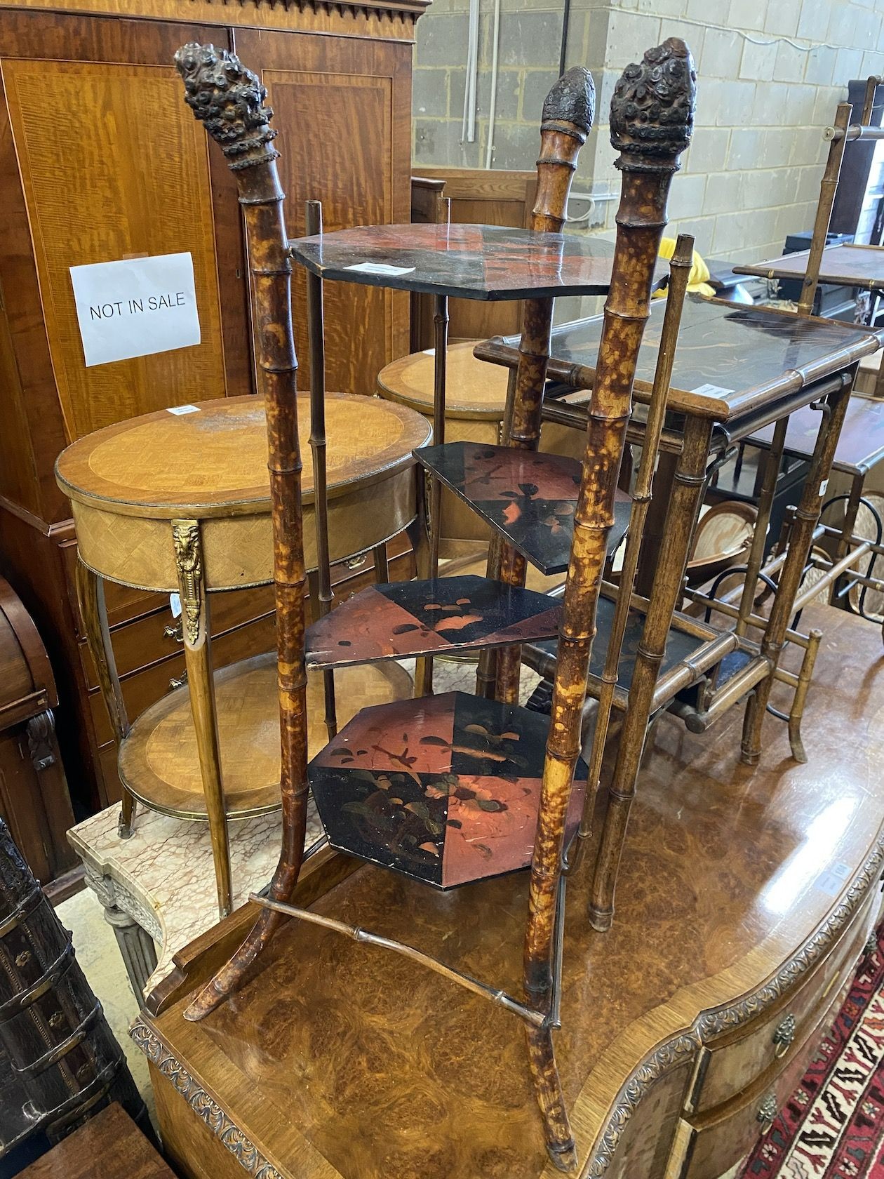 A Victorian three tier lacquer whatnot, with simulated bamboo uprights and a Victorian bamboo two tier table, with folding flaps and a lacquer and bamboo three tier table, largest height 103cm